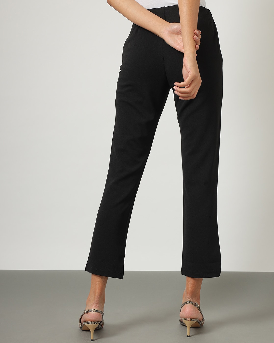 White straight capri trousers with invisible zip fastening on the side  slight slit on the leg and six goldcoloured buttons on