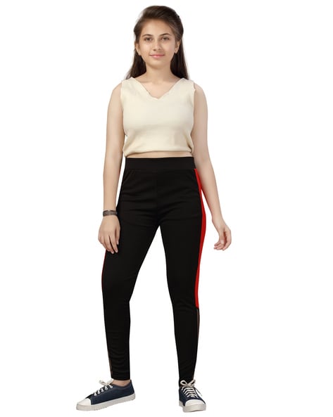 young girl in black pants, shirt and sneakers on a white background Stock  Photo | Adobe Stock
