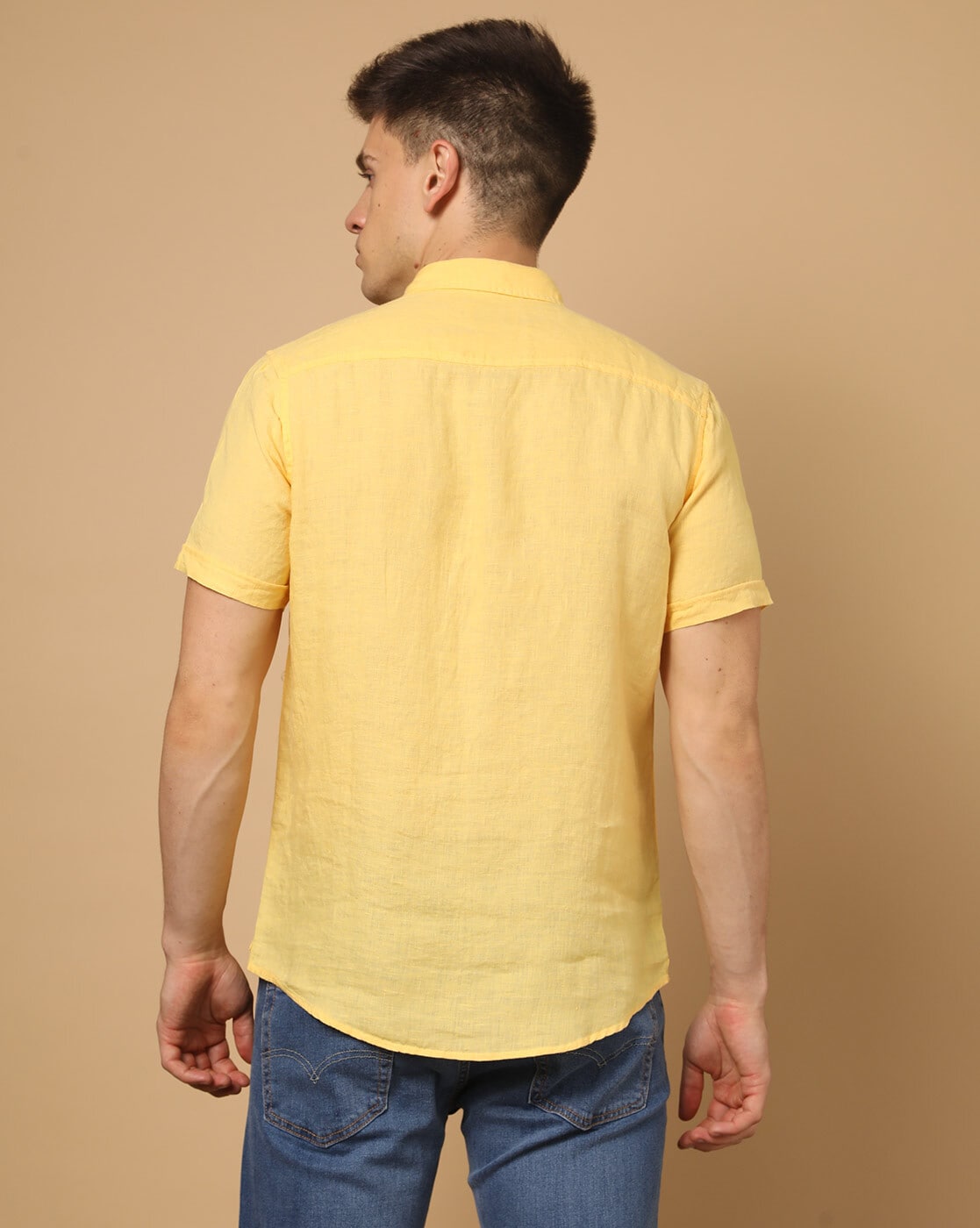 Young indian man wearing denim shirt standing over isolated yellow  background happy face smiling with crossed arms looking at the camera.  Positive person. Stock Photo | Adobe Stock