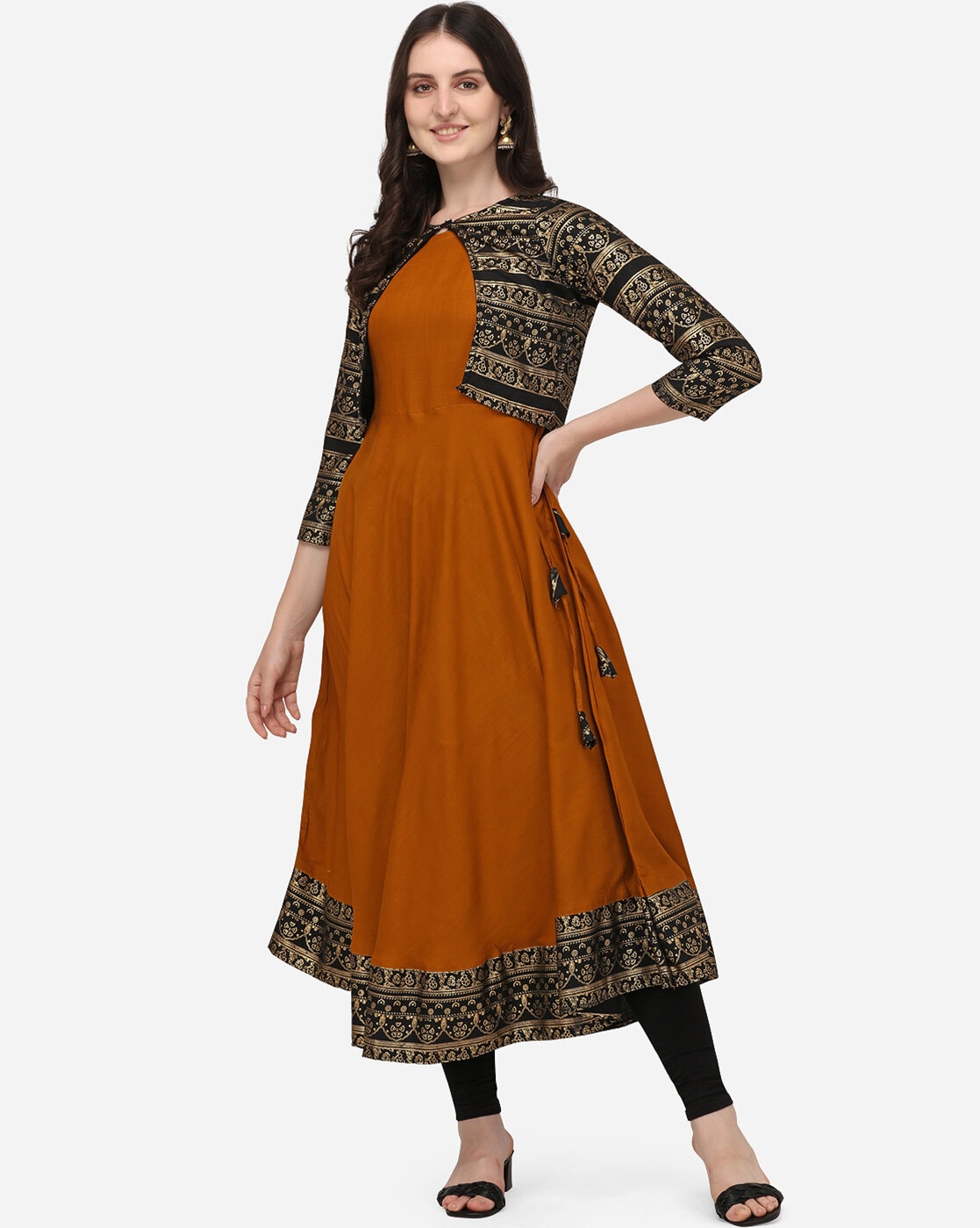 A-line sleeveless kurta paired with lace adorned jacket with churidar  sleeves having a front open tie-up detailed with tassels is ample for an  ethnic festive look.