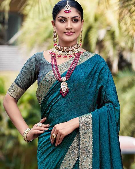 Photo of blue ink pattu sari with orange elbow length blouse and gold  jewellery