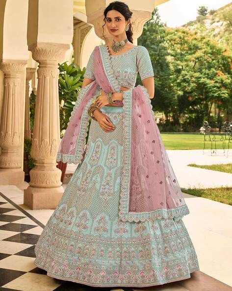Photo of Twirling bride in pretty pink and turquoise lehenga