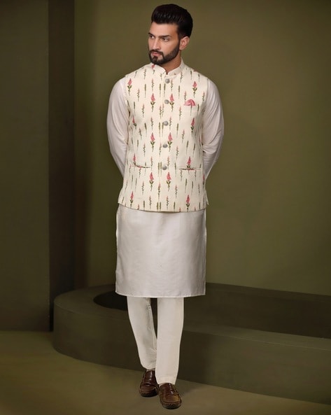 Photo of Groom in a floral print nehru jacket and white kurta pajama for  the Mehndi