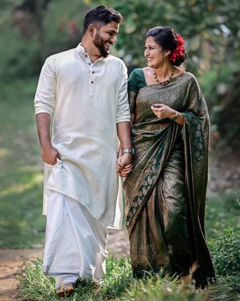 Free Photo | Lovely indian couple in love wear at saree and elegant suit  posed on restaurant back of them they looking on window and holds hands